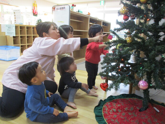 1歳児がクリスマスツリーを見ている写真
