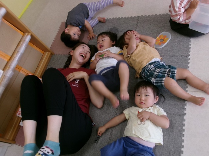 1歳児が保育者と触れ合っている写真