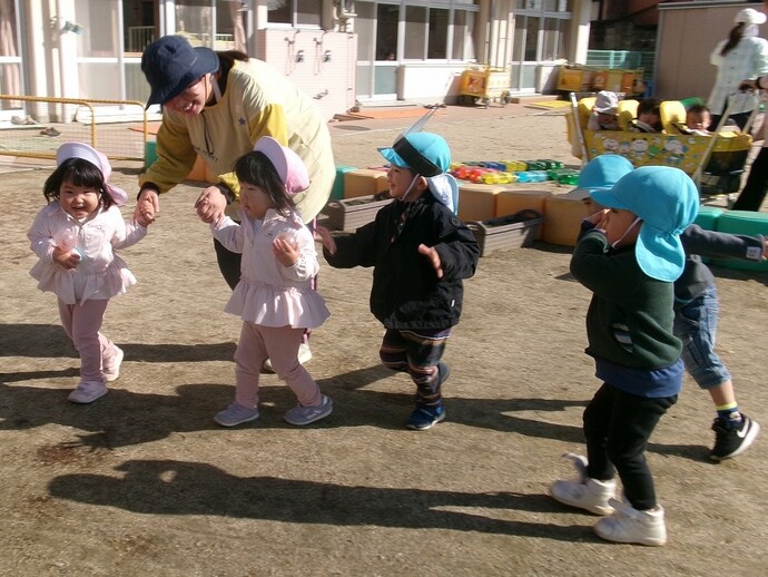 2歳児が保育者や友達と遊んでいる写真