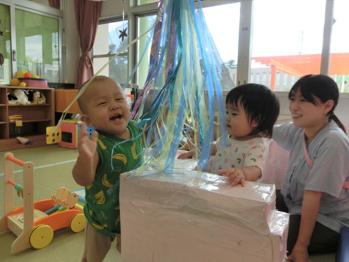 0歳児 いないいないばあをしている写真