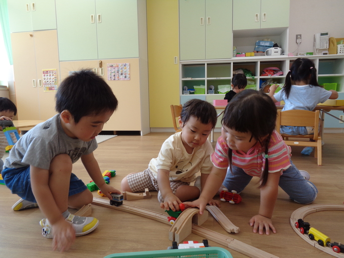 2歳児　線路で電車を走らせている写真