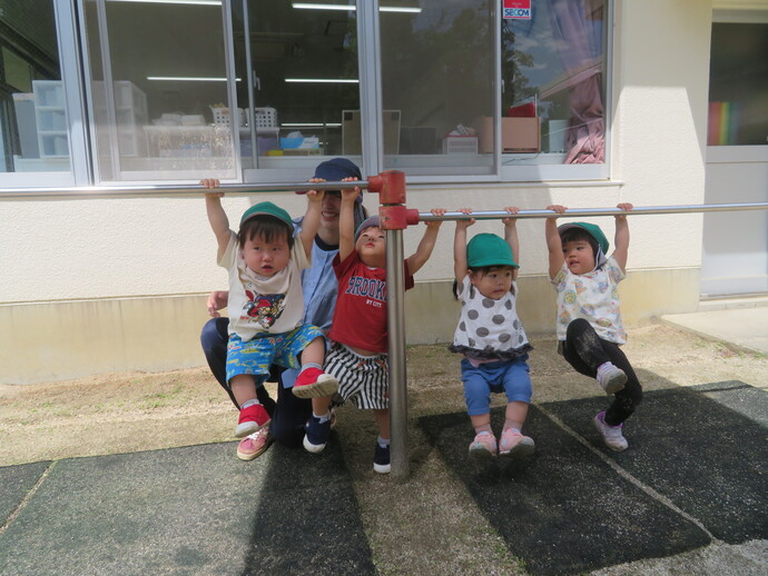 1歳児　鉄棒にぶらさがっている写真