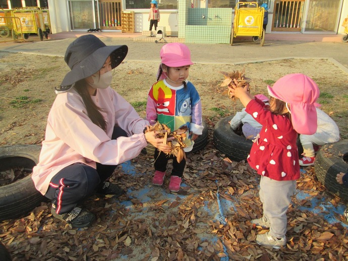 落ち葉で遊ぶ子ども