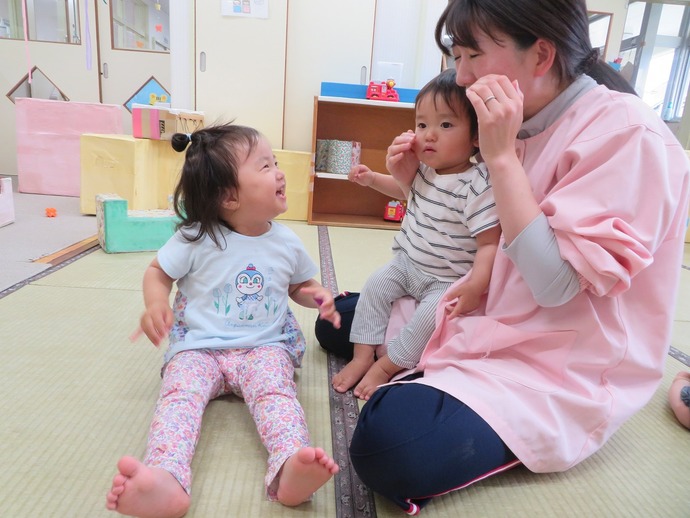 写真：歌遊びをする子どもと保育者