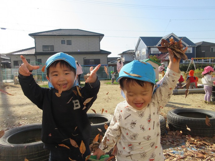 写真：はっぱで遊ぶ子どもたち
