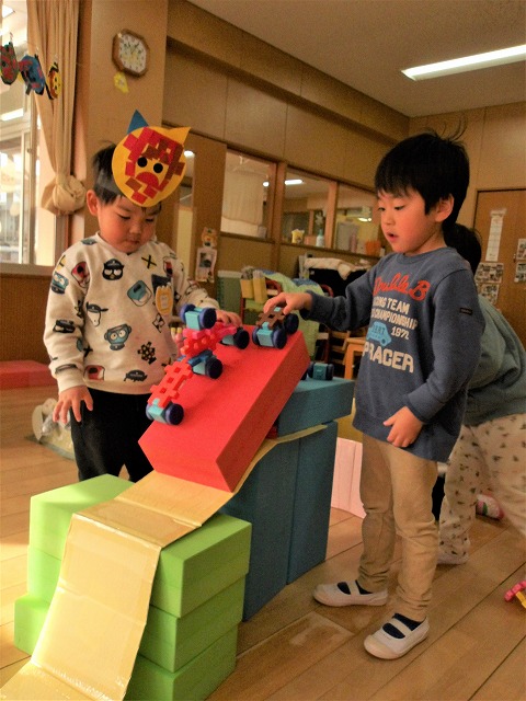 写真:ブロックで作った車を走らせる3歳児
