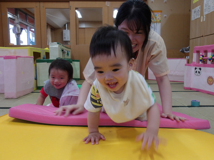 0歳児がマットの上を這っている写真