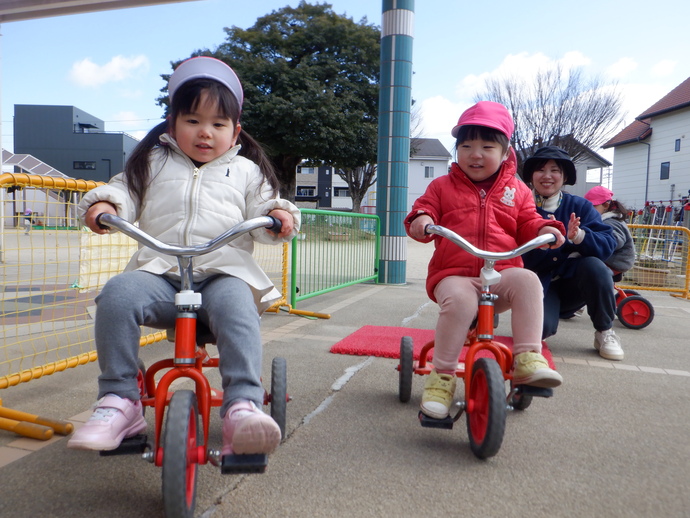 写真：三輪車に乗る2歳児
