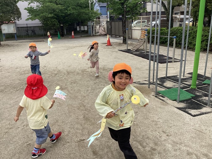 写真：年中児こいのぼりを持って走っている