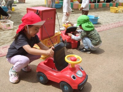 写真:年少児 三輪車を繋げて遊んでいるところ