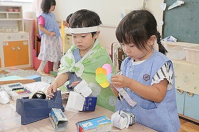 写真：年中児　ごっこ遊びでいるものを自分で作る様子