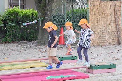 写真：年中児　平均台を渡ってサーキット遊びをする様子