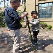 写真：男児が竹馬に乗り、男性が支える