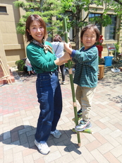 写真:竹馬に乗った子どもと支える保護者