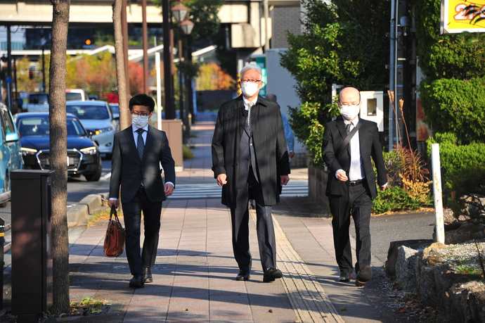 市長が歩いて市役所へ向かっている様子
