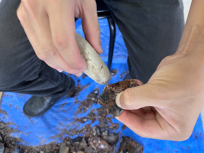 河原石のハンマーで剥片を成形する作業