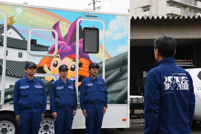 被災地へ派遣されるトイレトレーラーと市職員の写真