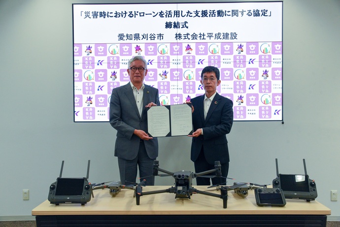 締結書をもって記念撮影する原副社長と市長